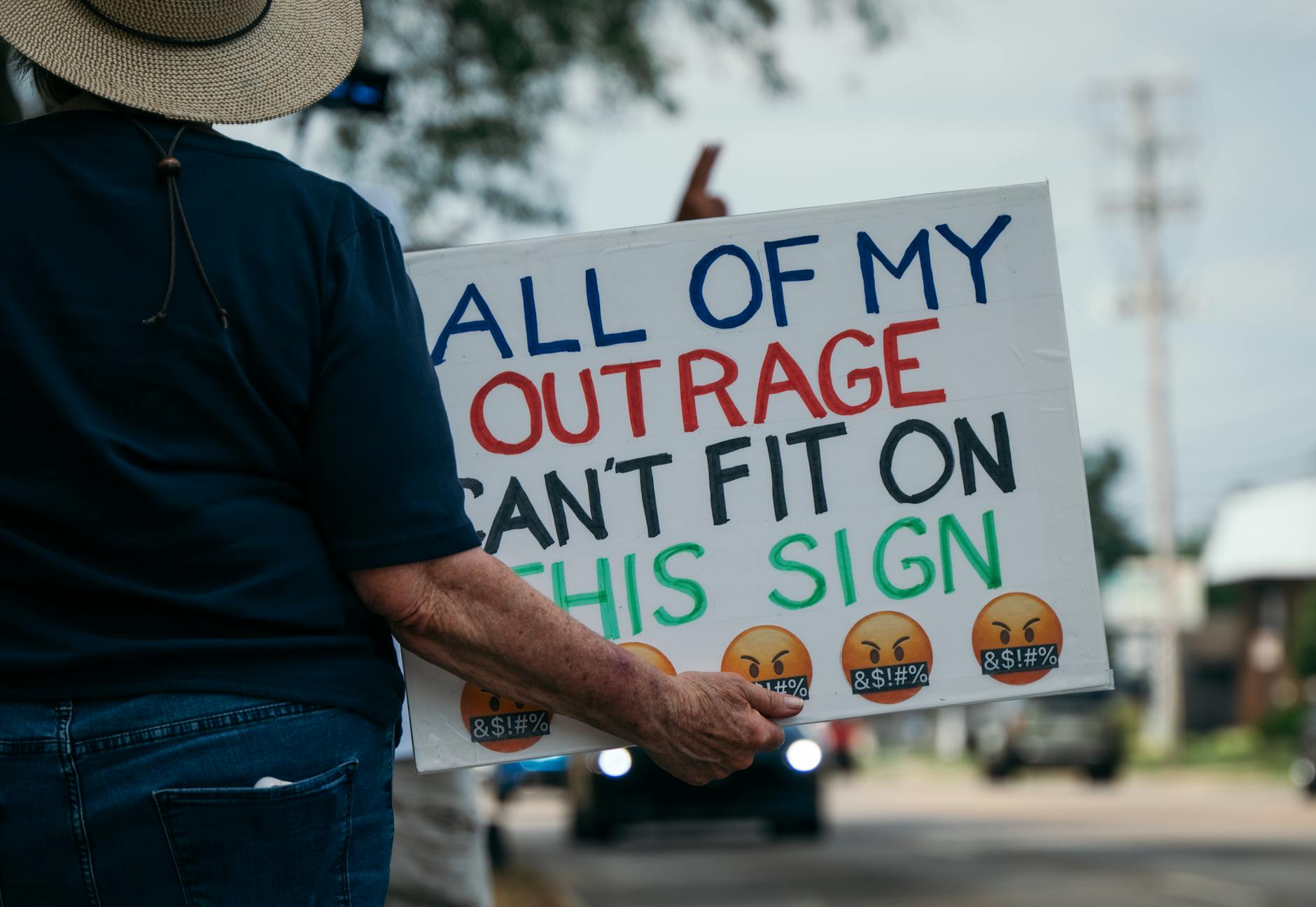 protester holding outrage sign at a rally